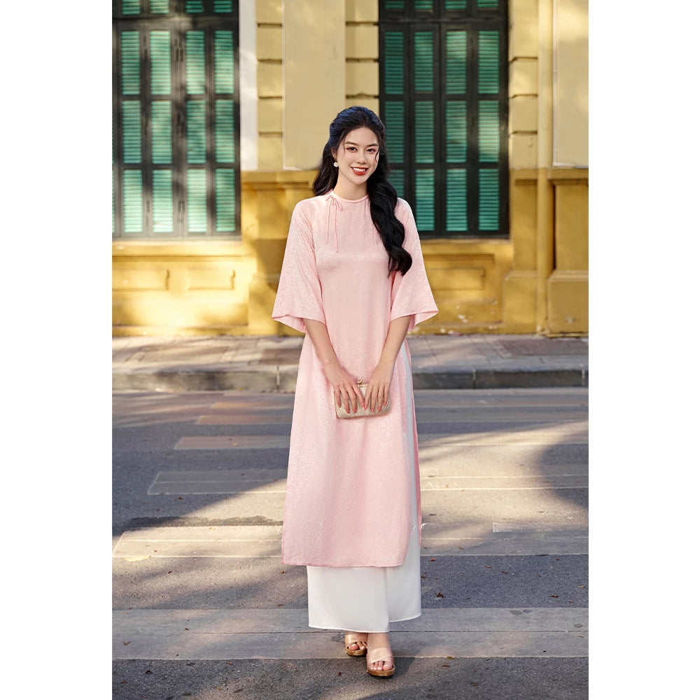 Loose-fitting brocade Ao Dai with a bow detail at the neckline, a trendy modern Ao Dai for 2026 - Moc An Ao Dai 